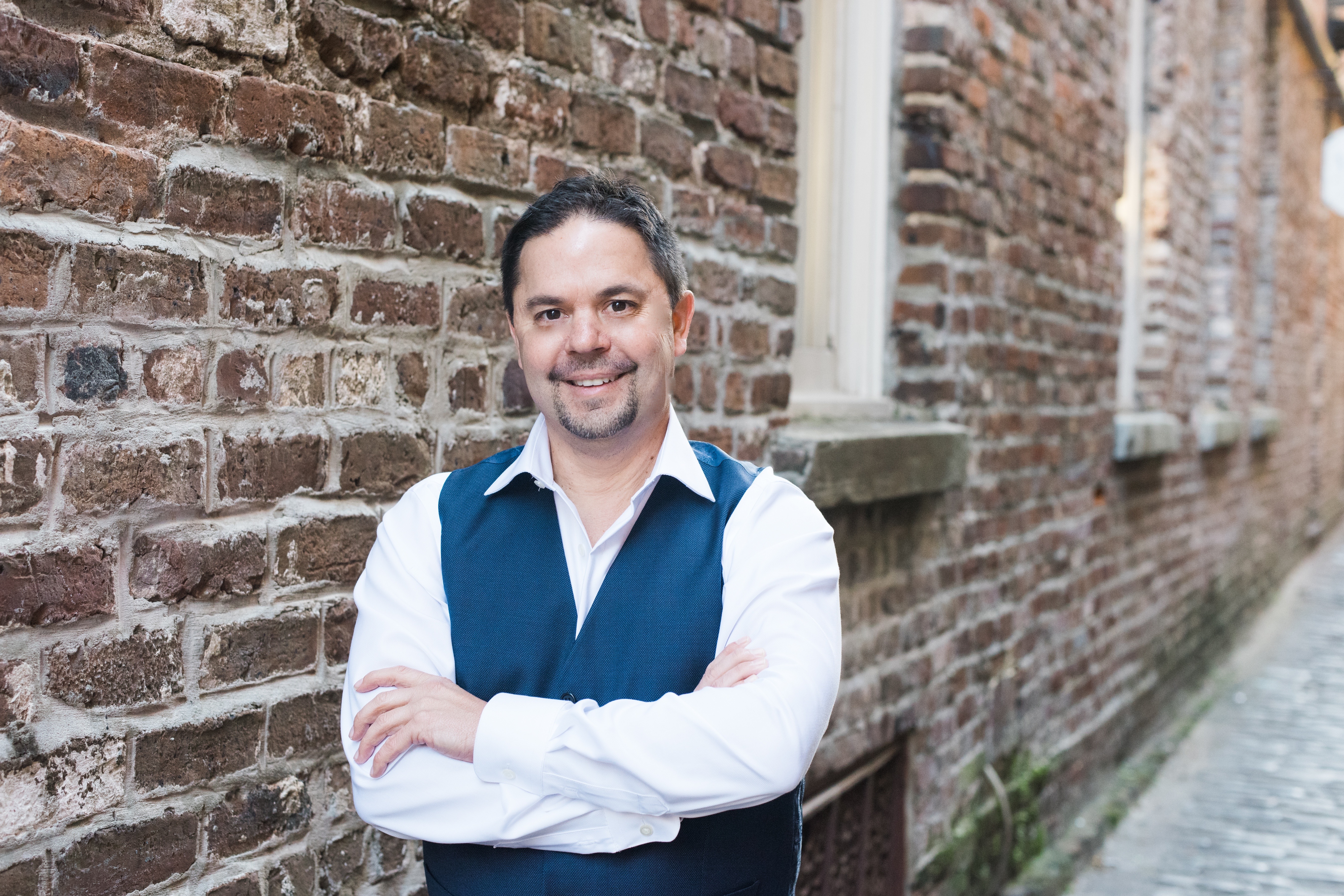 Frank Guy standing in a Charleston brick alley