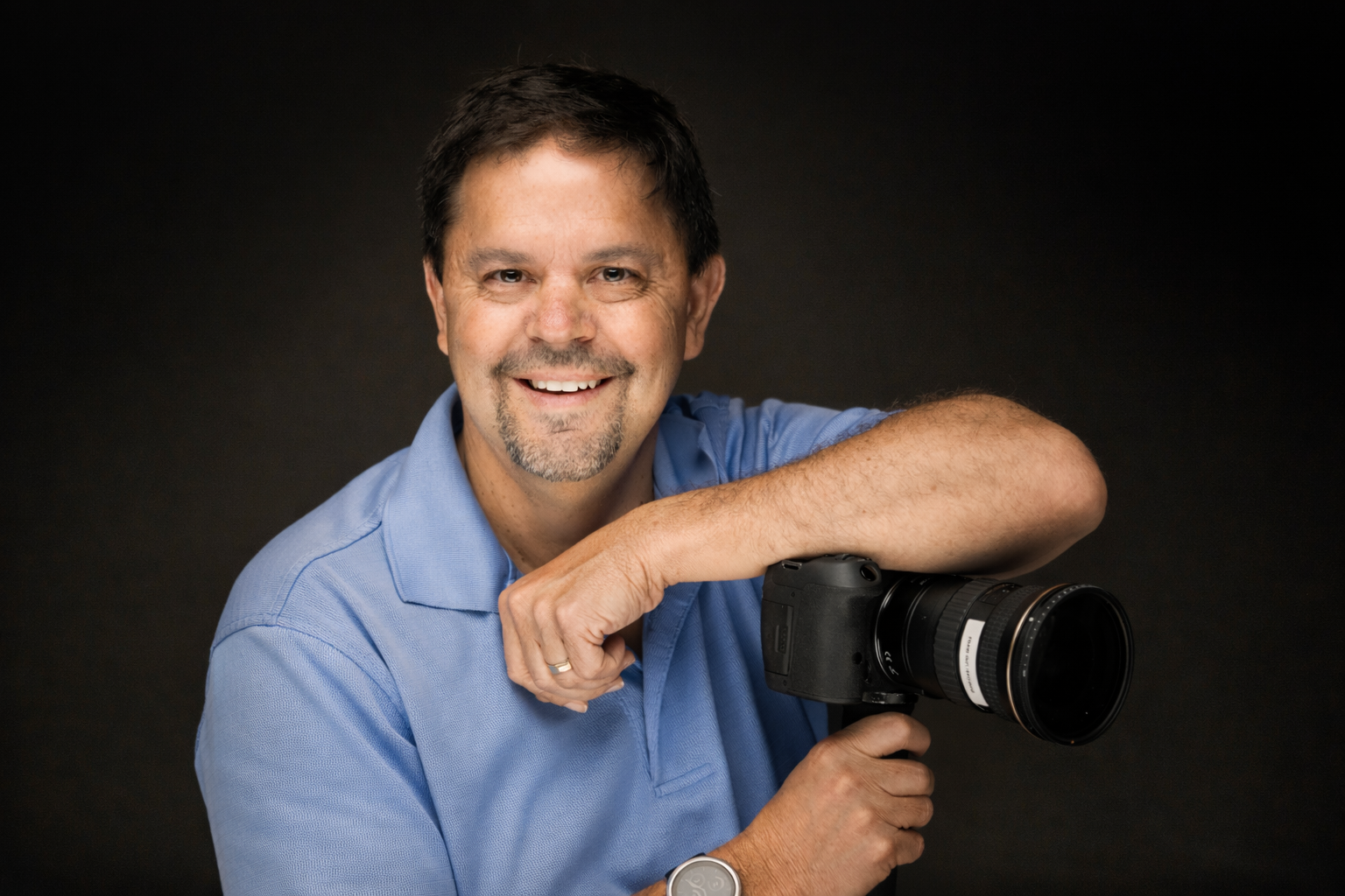Frank Guy smiling while holding a camera
